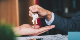 A hand putting a ring of keys onto a open palm