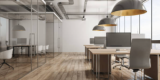 an office space with a row of desks on one side and meeting rooms on the other side